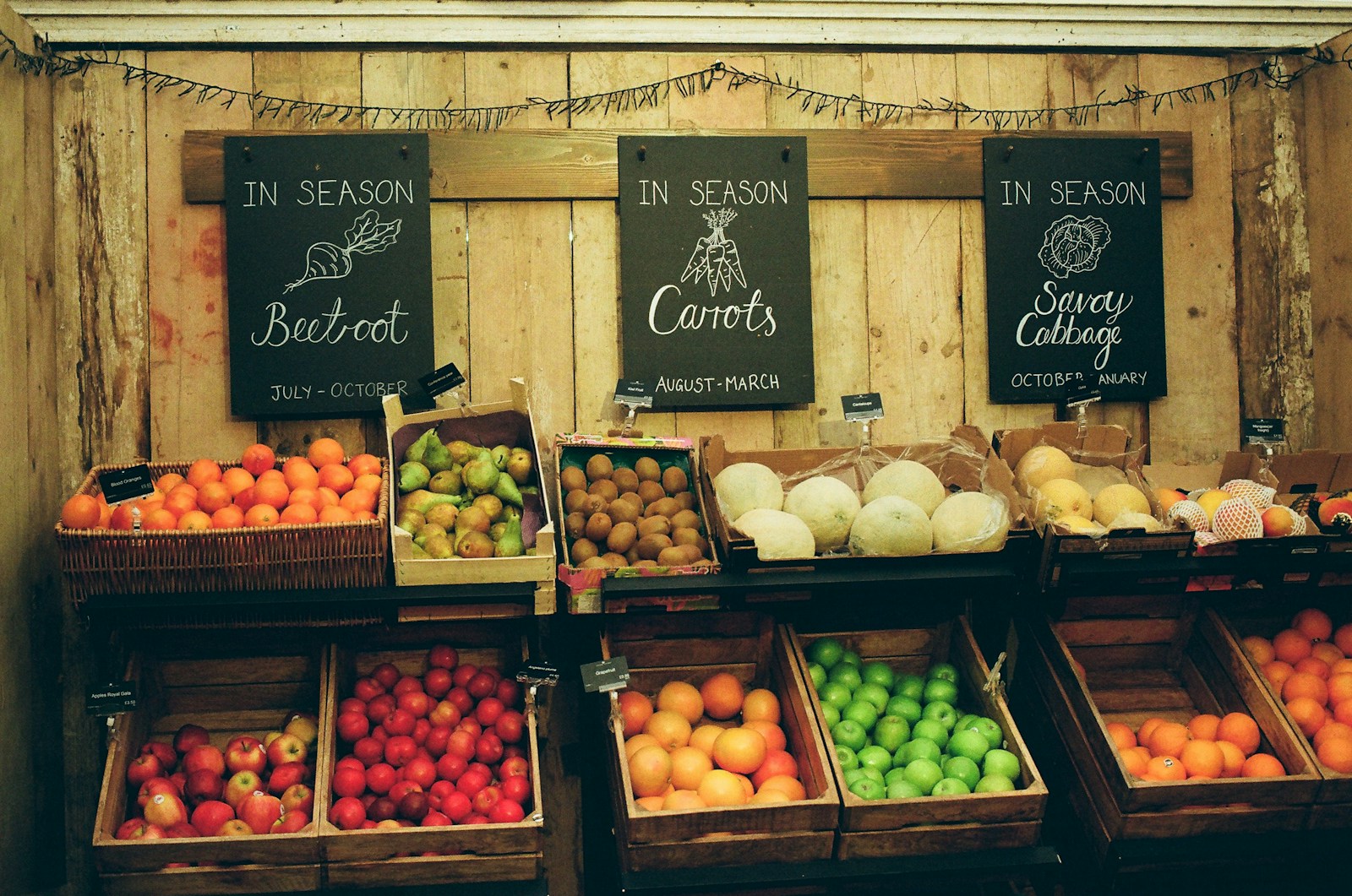 Wooden crates of just-picked produce at a farmers market.