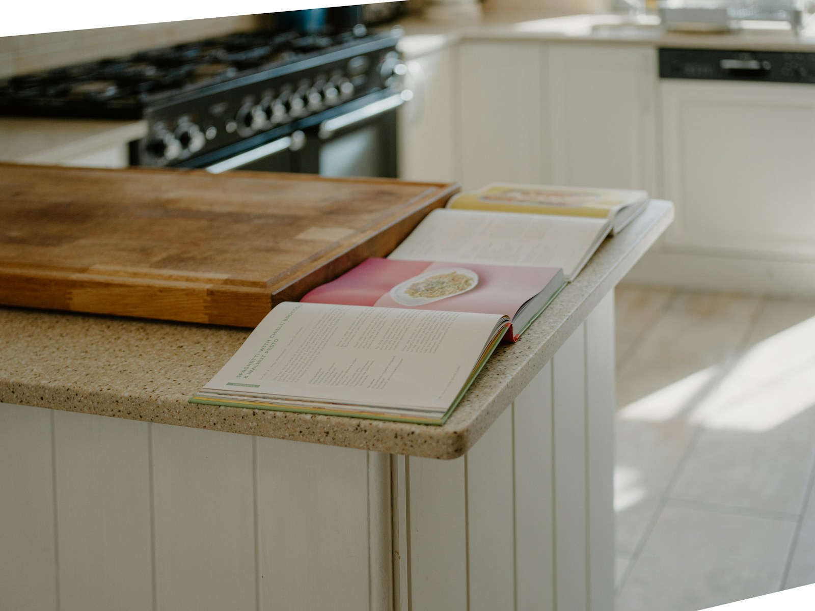 An open cookbook resting on a warm kitchen counter.